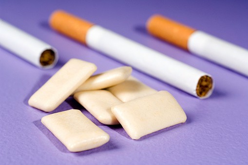 sigarette e gomme da masticare su sfondo viola
