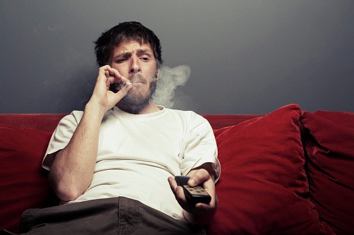 uomo che fuma e guarda film in tv